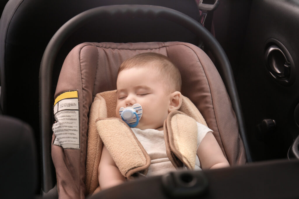 Immagine esempio per articolo Il primo viaggio in auto col neonato con di bambino che dorme nel seggiolone auto