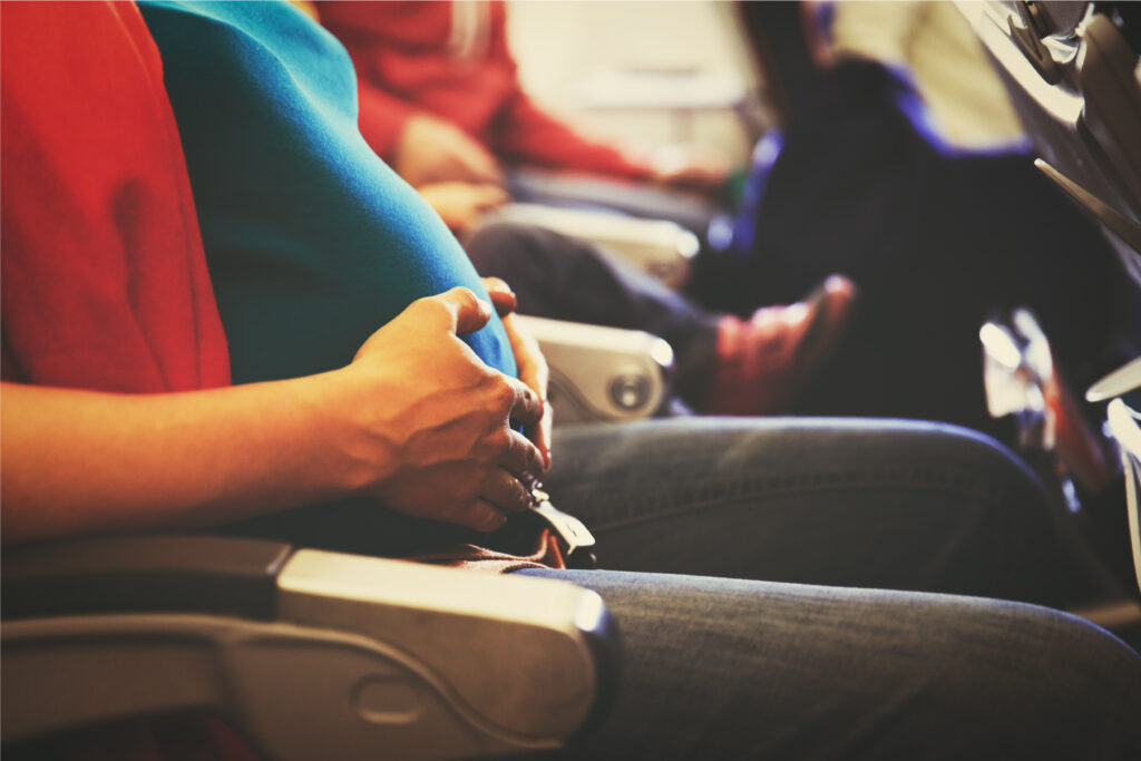 Immagine esempio di mamma in attesa seduta in aereo con la cintura di sicurezza sotto il pancione